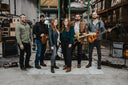 Band posing with instruments in a warehouse setting