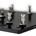 A close-up view of a black British 50W turret board with turrets & cut outs.