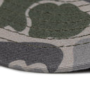 A close-up image of a Mojotone leather patch trucker cap in Bottomland camo.