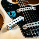 Close-up of a guitar's bridge and strings on a wooden background
