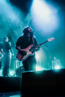 Person playing guitar on stage with blue lighting
