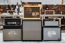 Stack of guitar amplifier cabinets in a workshop setting