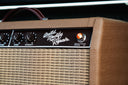 Close-up of a guitar amplifier with 'Build. Modify. Repair.' label on a dark background